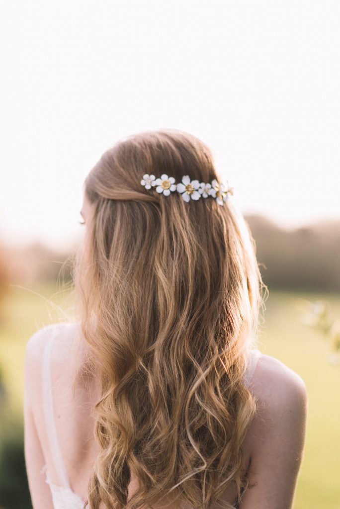 Blonde hair bride with half up hairstyle and daisy hair clip