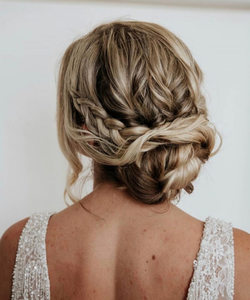 Tousled bun with texture and plaits on blonde bride with highlights